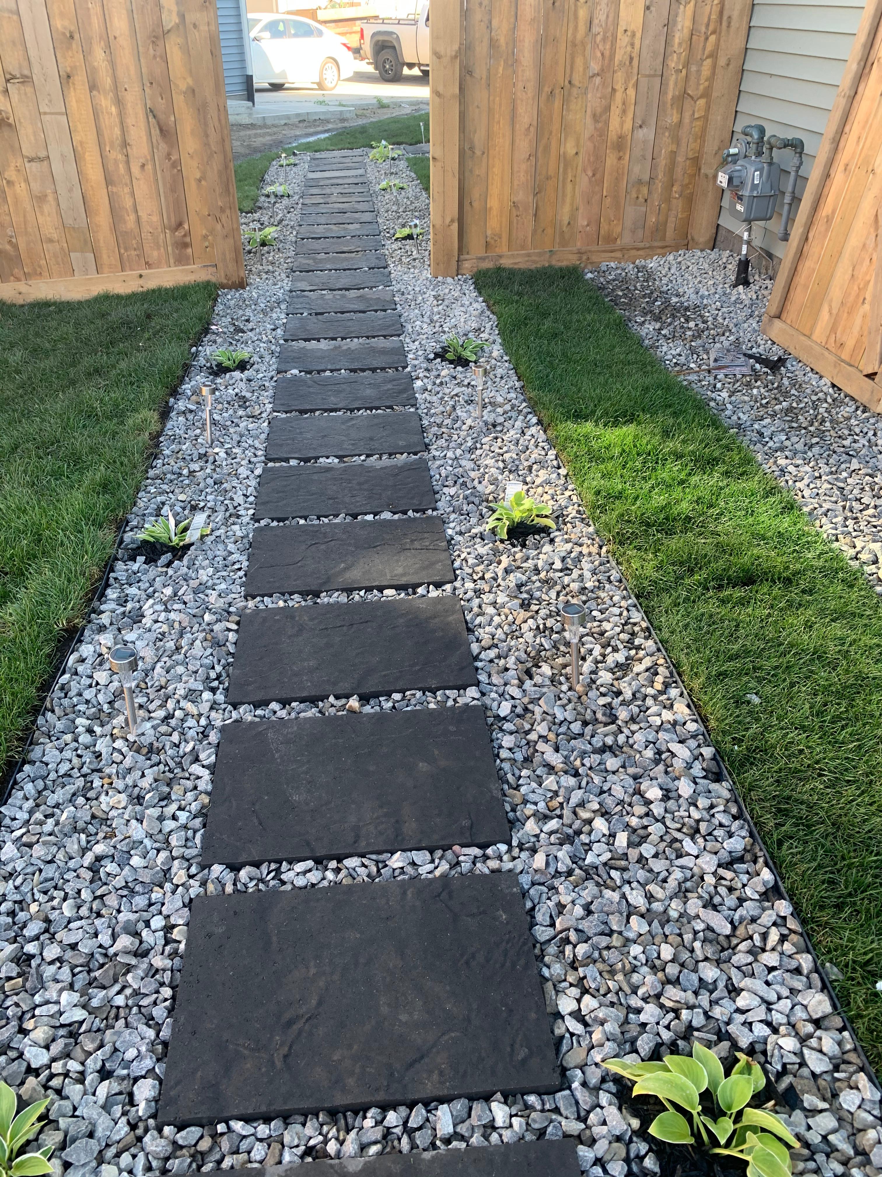 Side yard stepping stone pathway with dark slate pavers and white river rock